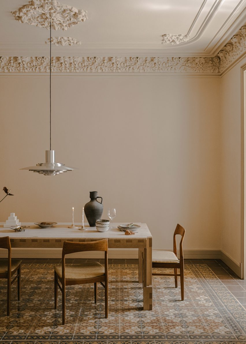 Dining table in room with mosaic floor tiles and ceiling mouldings