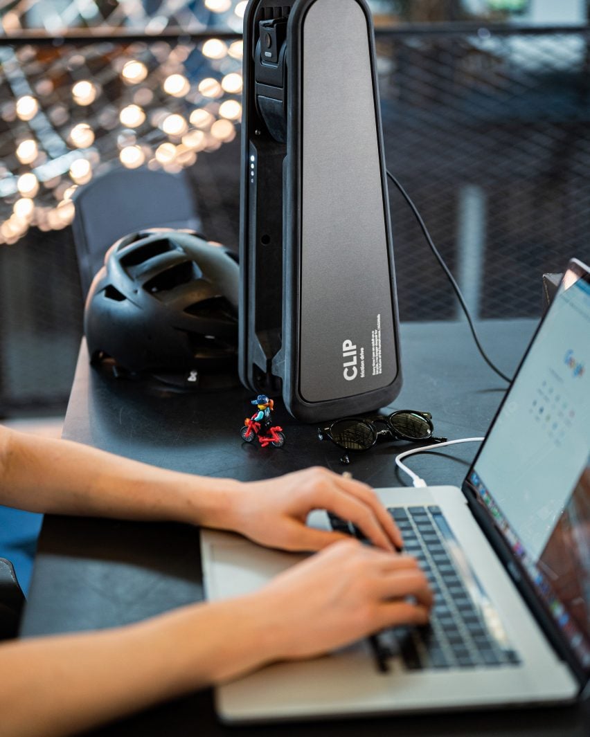 CLIP device stored on desk beside person working