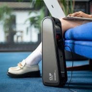 E-bike device charging on the floor with person working on laptop