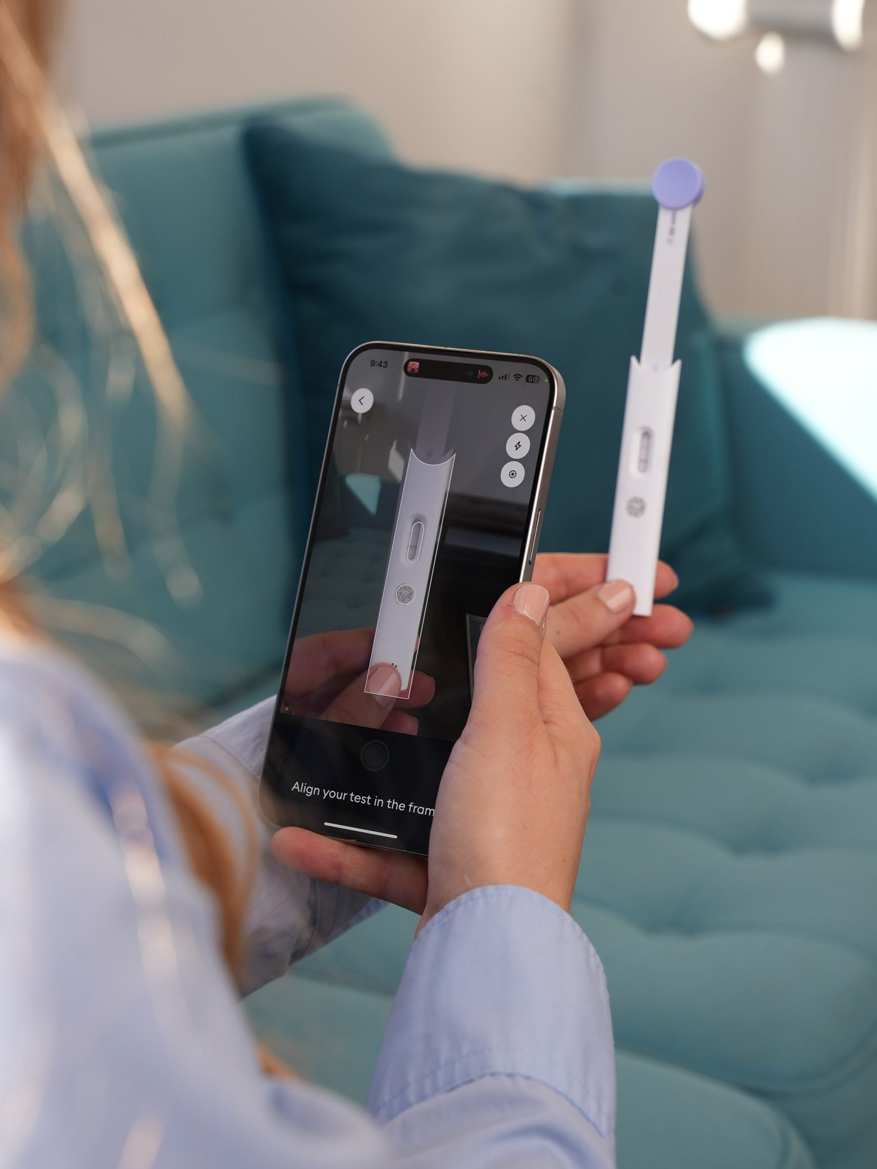 Photo of a person holding up their phone camera to their Hormometer test cartridge