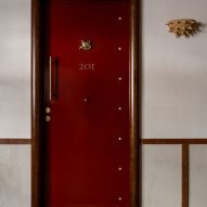 Red gloos door with wolf knocker and anenome wall light