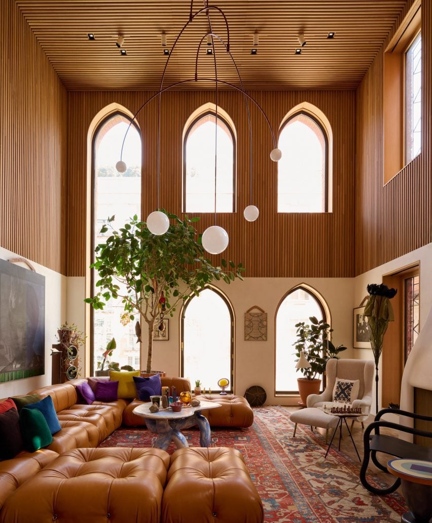 A double-height living area with arched windows and reeded oak panels across the upper portion