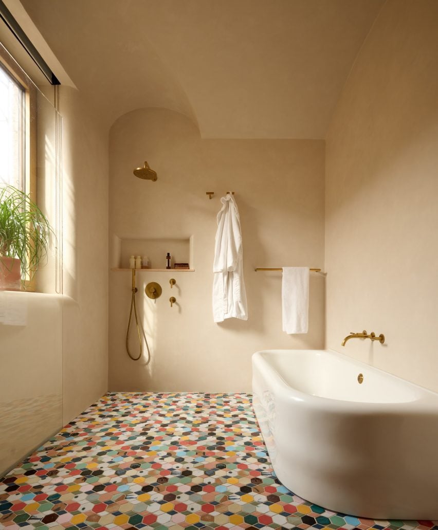 Plastered bathroom with colourful hexagonal floor tiles