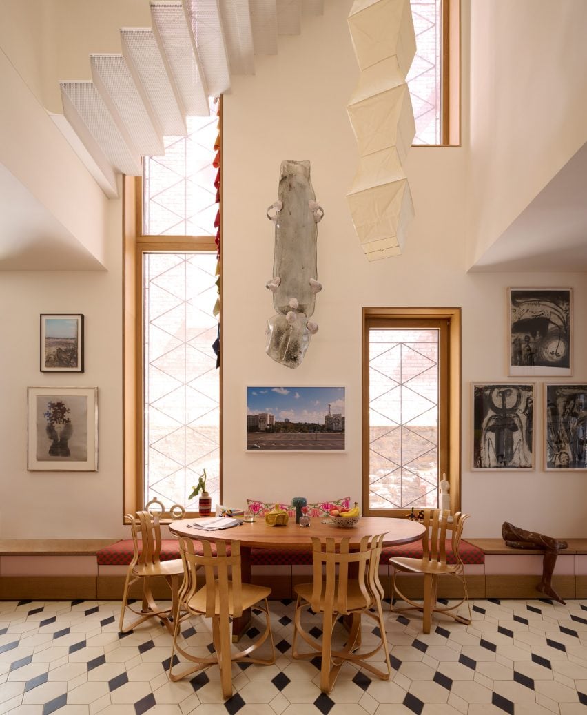 A perforated white metal staircase above a breakfast nook