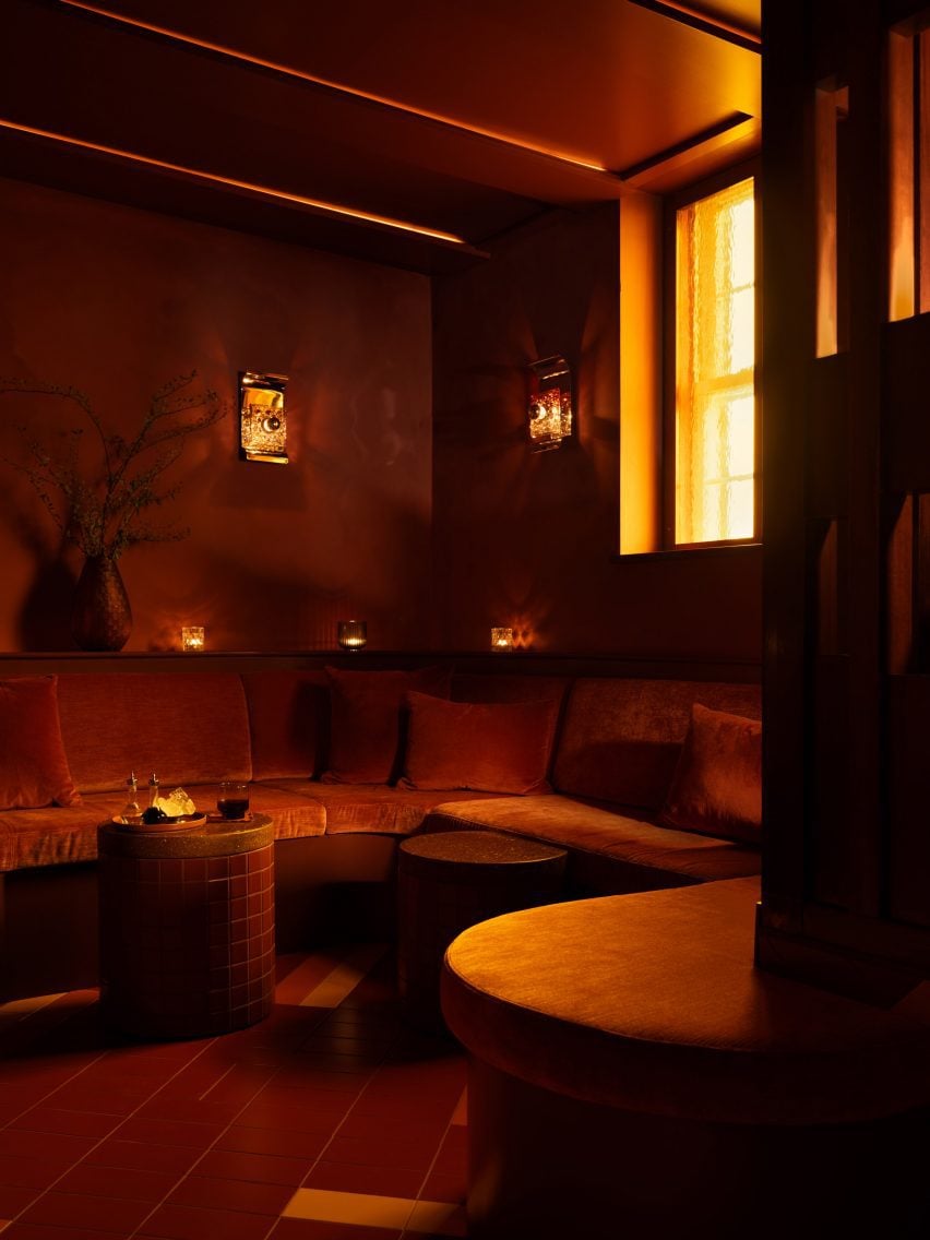 Bar seating area with 1970s cast-glass sconces and amber window panes