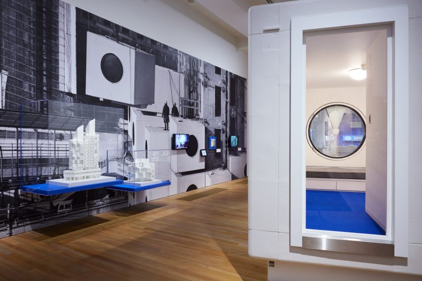 Living pod beside architectural model at exhibition