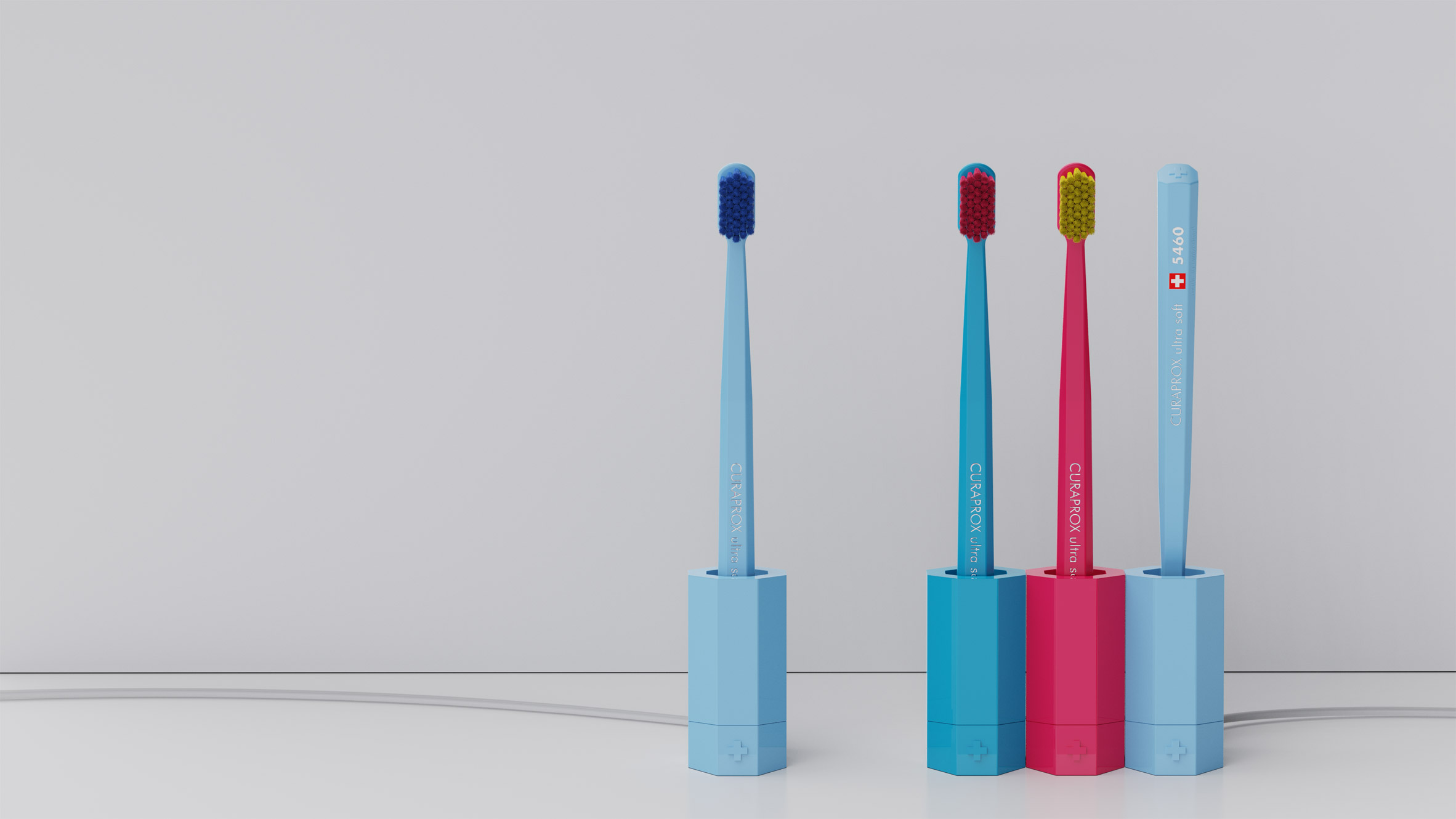 A photograph of four toothbrushes in hexagonal holders, in tones of blue and pink.