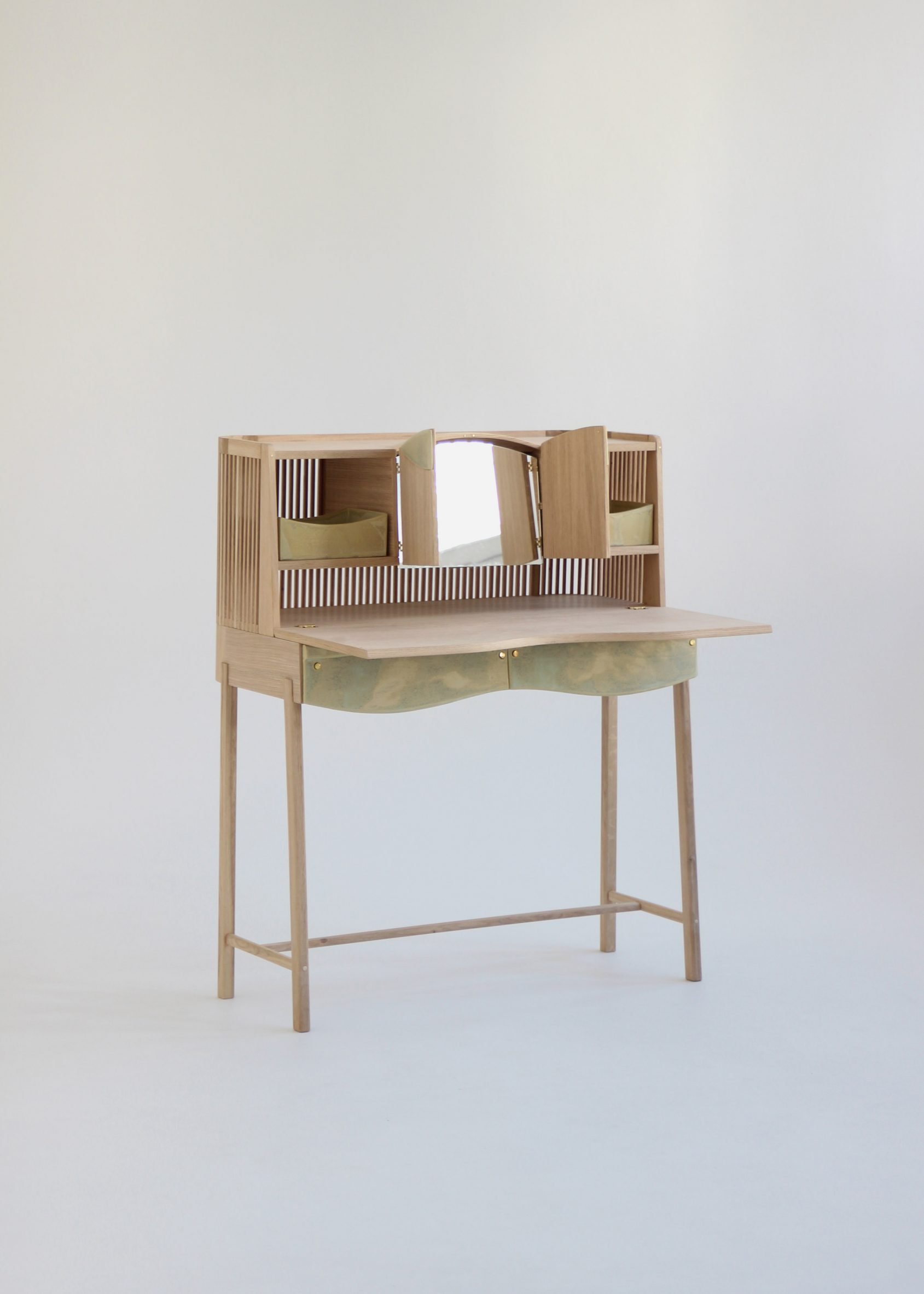 A photograph of a beige wooden dressing table against a grey backdrop.