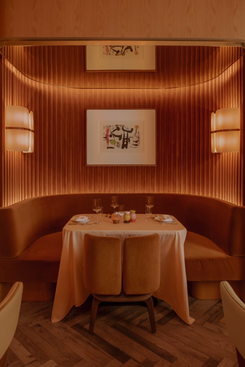 Banquettes within a niche lined with reeded velvet panels