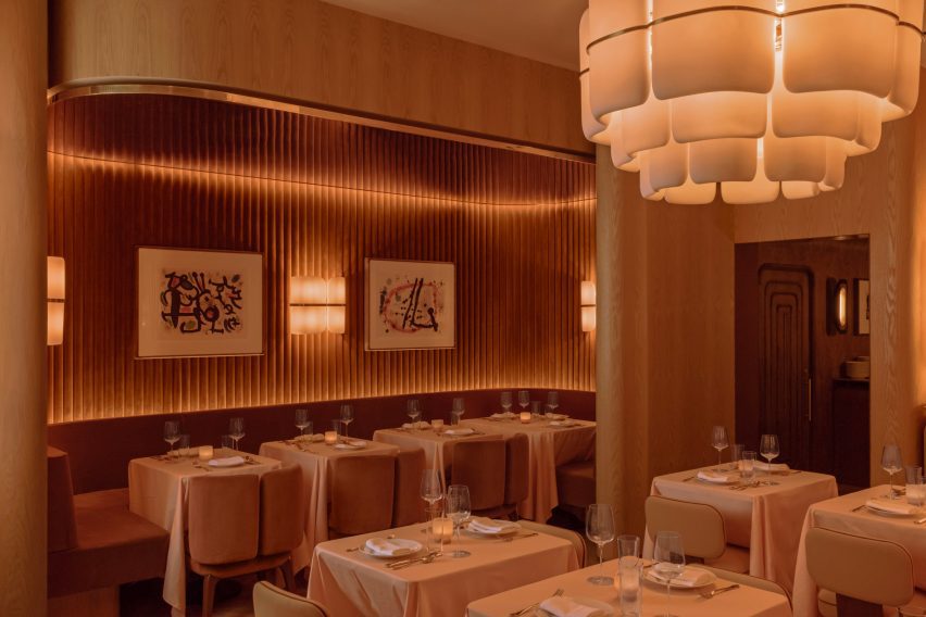 Restaurant interior bathed in soft, warm light from sconces, pendants and cove lighting