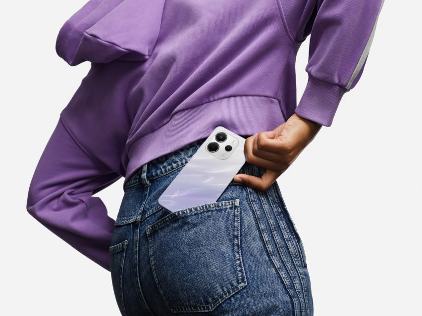 Person holding smartphone in front of light grey background