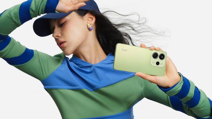 Person holding smartphone in front of light grey background