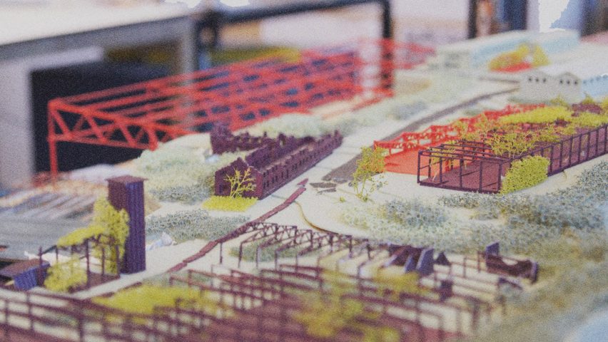 A close up photograph of an architectural model, in tones of purple, red, green and white.