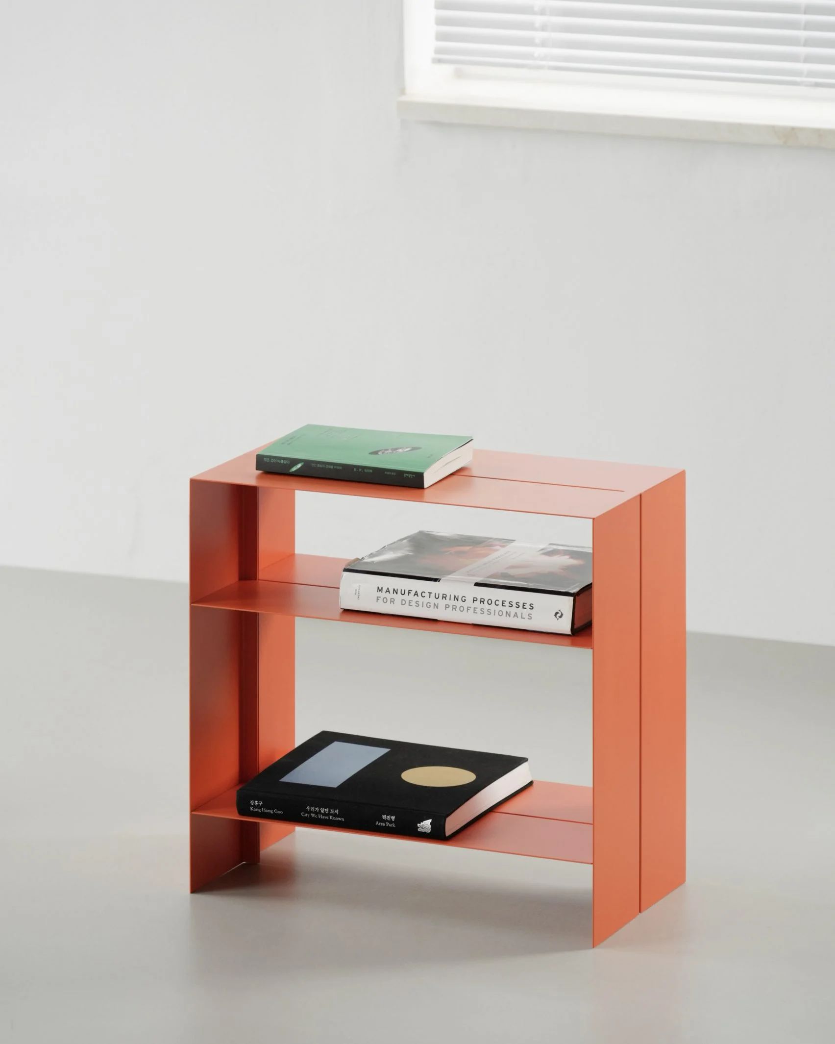 Orange shelving unit made from thin metal 