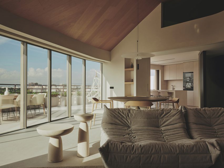 Photograph of an open-plan living and dining space with a large glass facade offering views of Valencia city