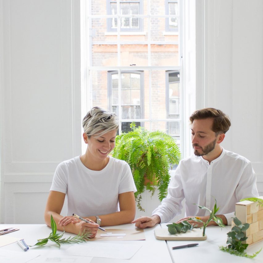 a photograph of two people working at a desk