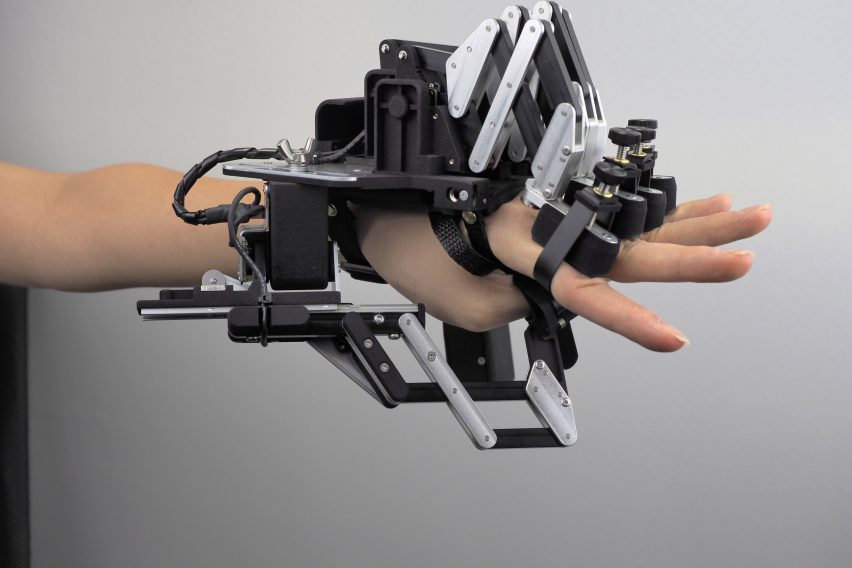 Photo of a hand wearing a bulky robotic exoskeleton