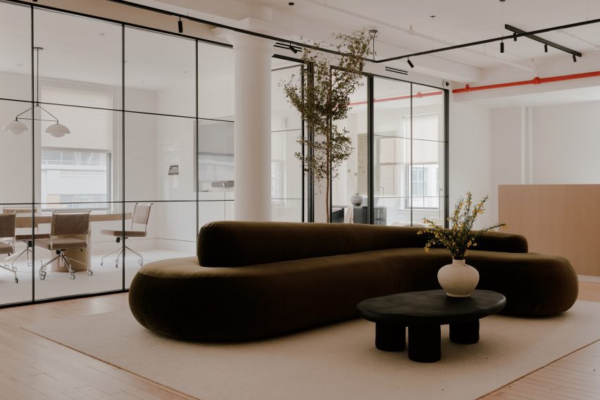 Reception area with large olive-green sofa and a tree behind