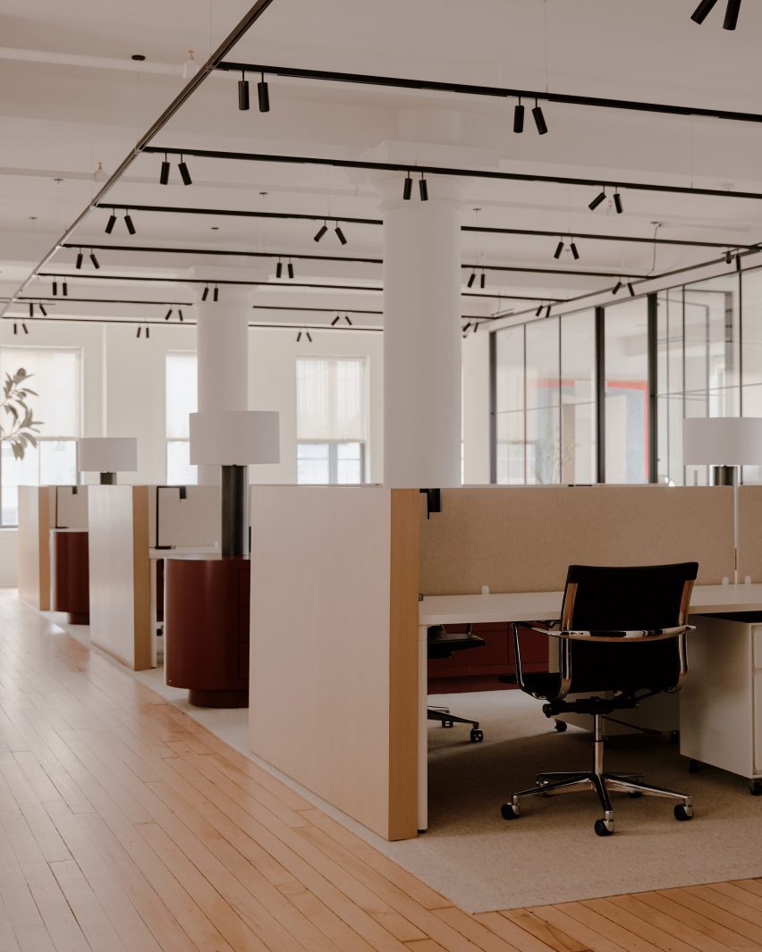 Desks tucked into rows of booths in an office area