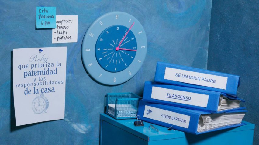 A photograph displaying a stack of ring binder folders on a table, with a clock and pieces of paper on the wall behind them. All the objects are in tones of blue.