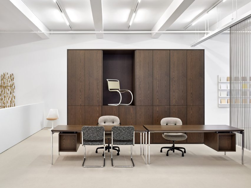 An office vignette with dark wood furniture and upholstered chairs