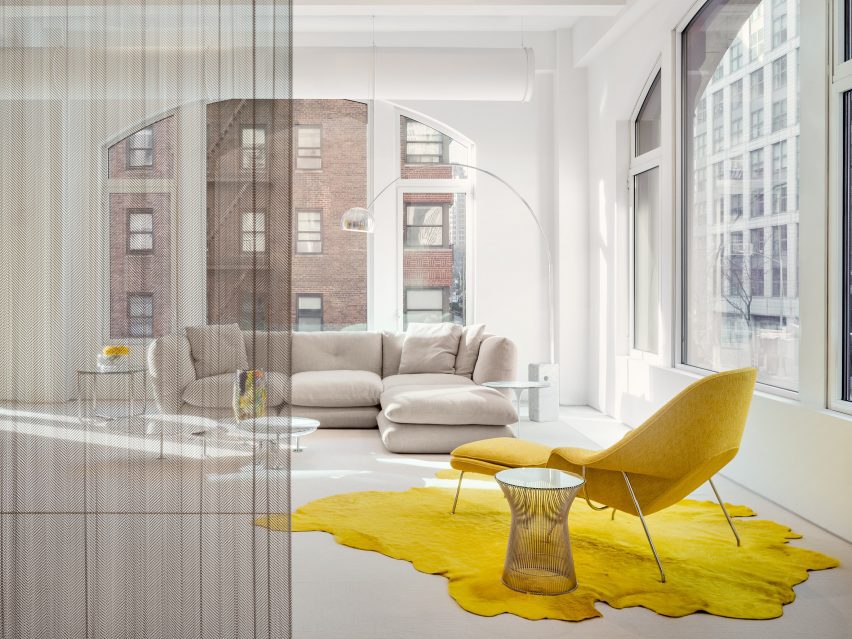 Furniture showroom with large windows and a bright yellow chair on a matching rug
