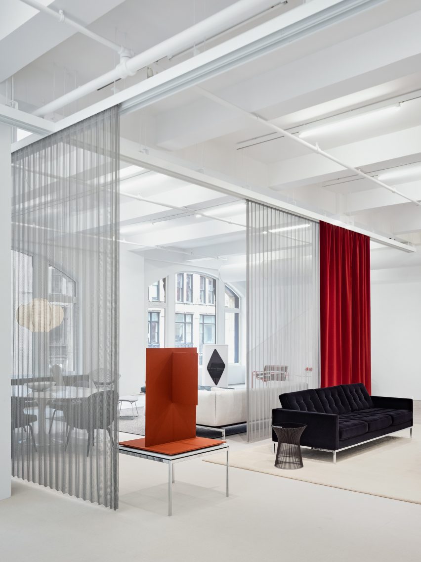 Minimalist furniture showroom with curtains of metal mesh and brightly coloured fabric