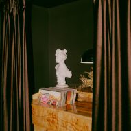 Records in wooden holder behind brown curtains