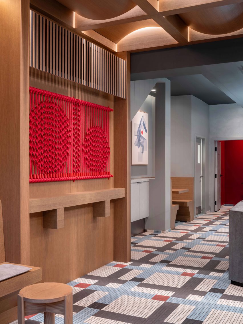 Red macram&eacute; artwork mounted on oak-panelled wall