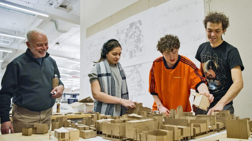 A photograph of a group of students interacting with architectural models.