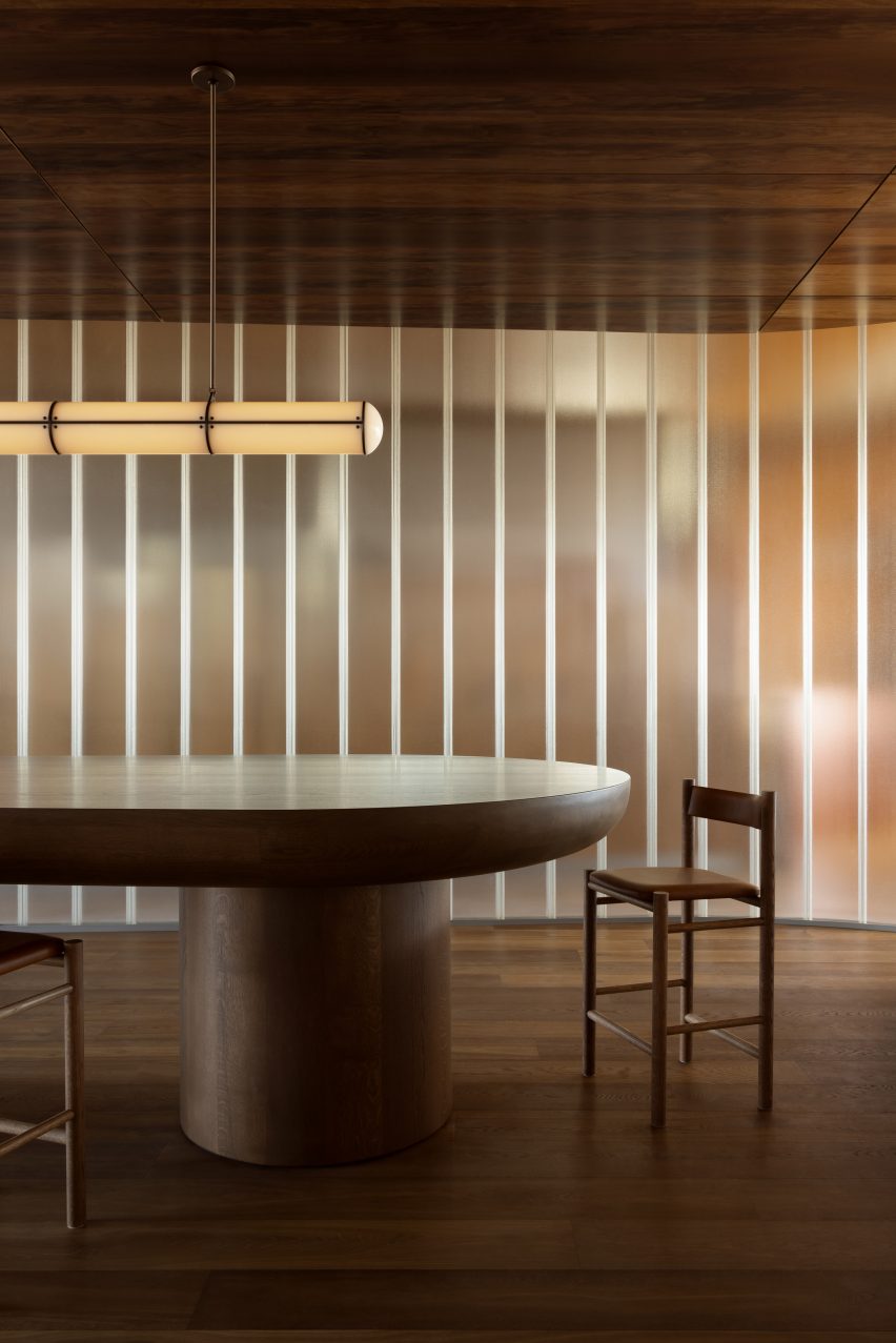 Chair and table in front of lit glass wall