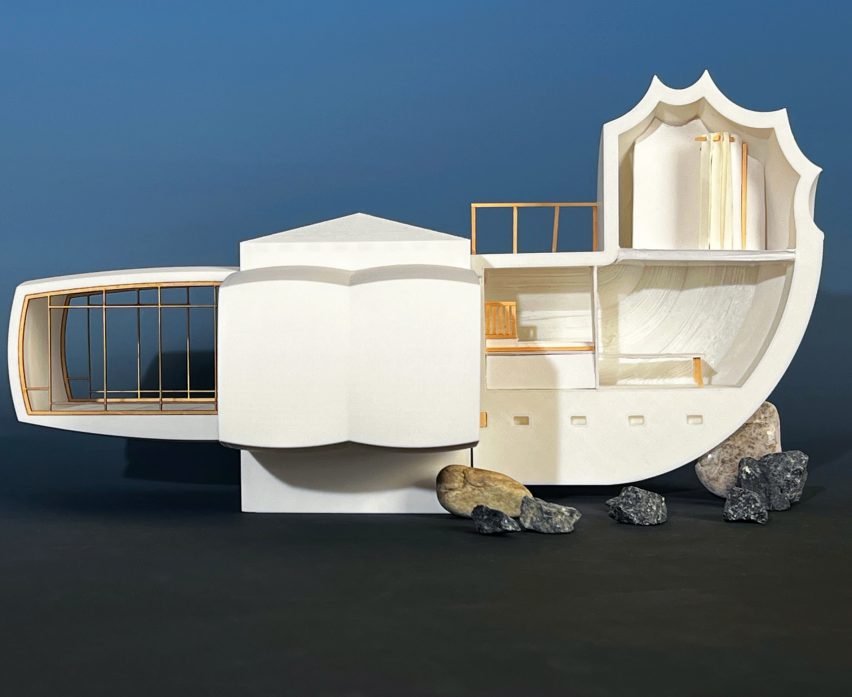 A photograph of an architectural model in tones of white, against a dark blue backdrop.