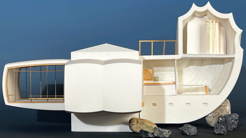 A photograph of an architectural model in tones of white, against a dark blue backdrop.