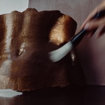Photo of hand brushing torso sculpture