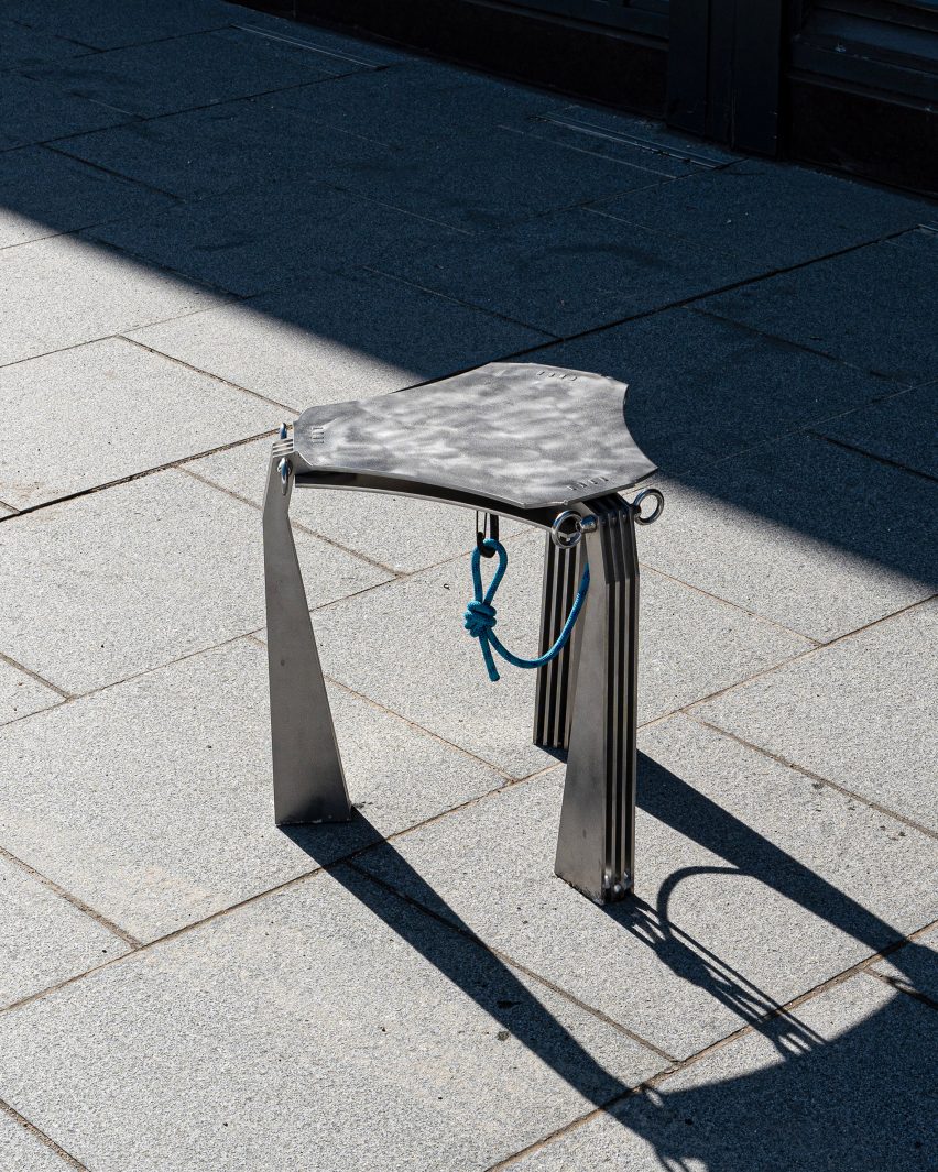 A photograph of a metal stool on concrete