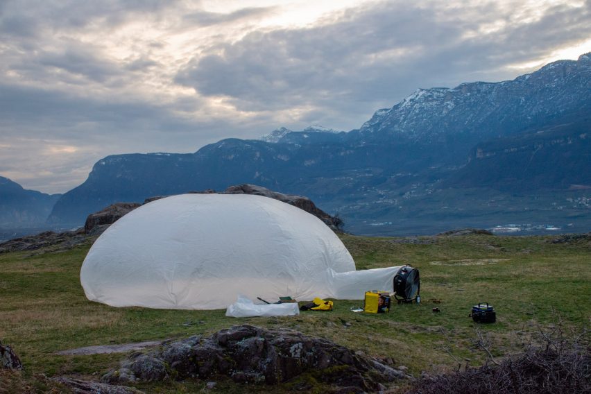 A photograph of a circular white tent in a green field.