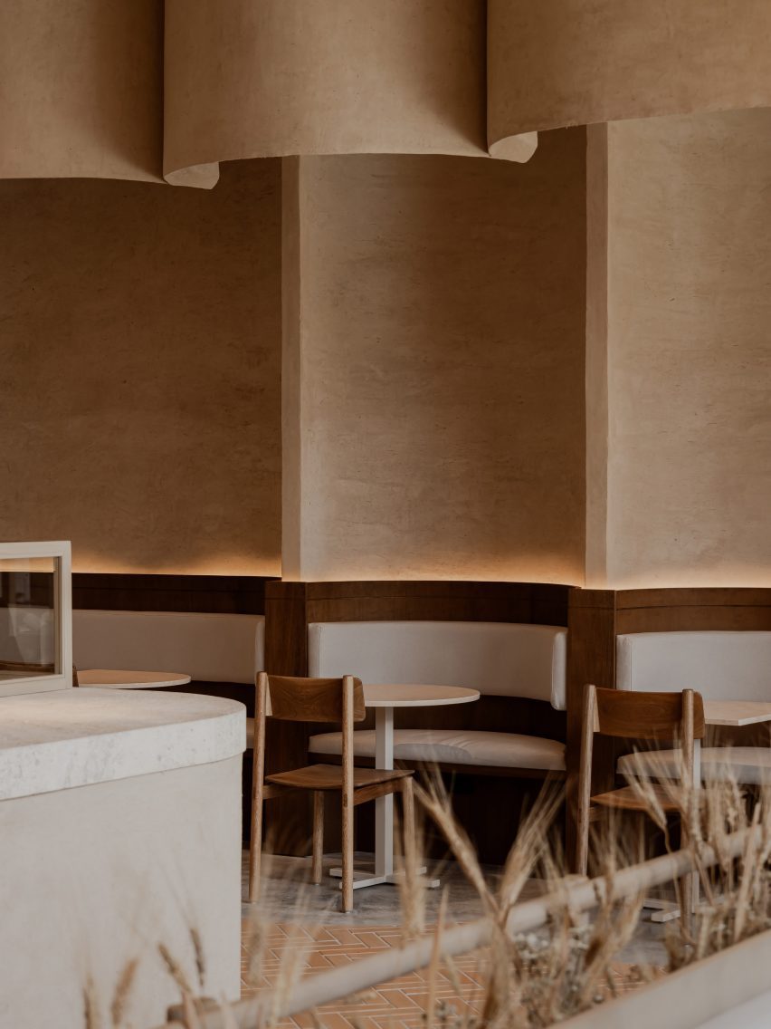 Walls lined in clay plaster and shaped to create niches for booth seating