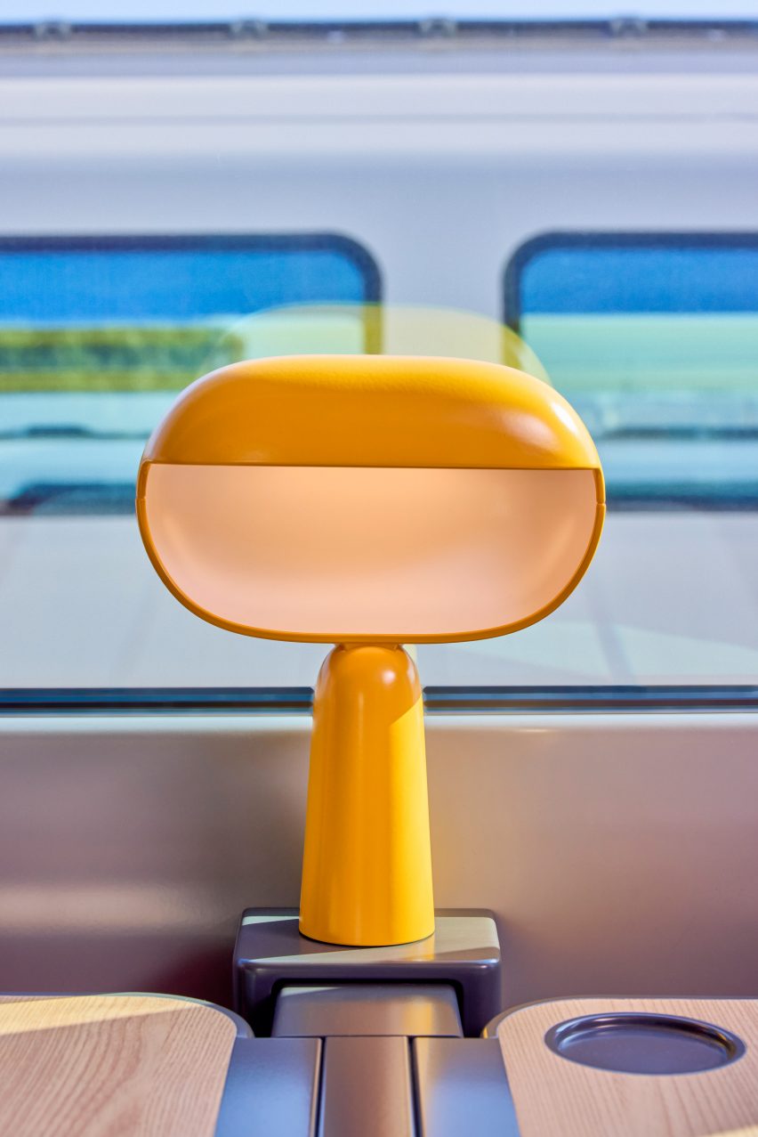 Yellow table lamps in train interior by Nendo and Arep