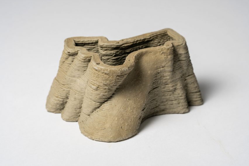 a photograph of an abstract-shaped clay object in tones of brown