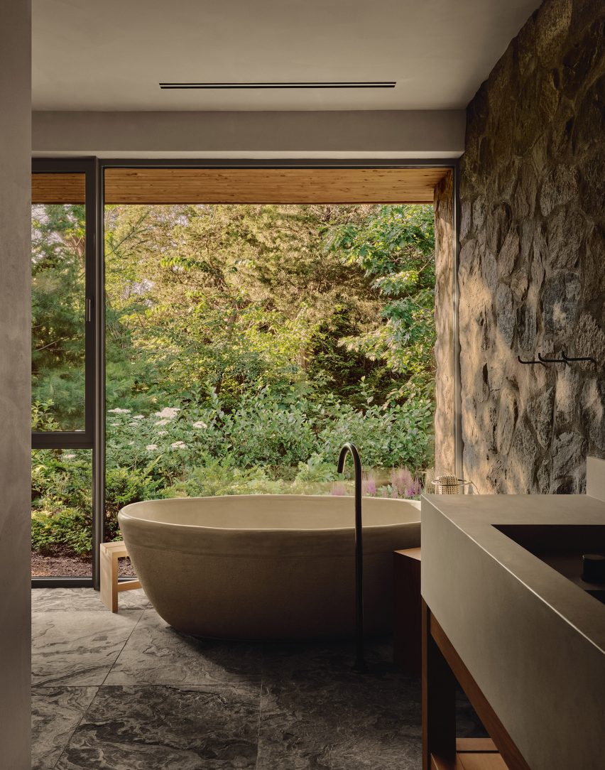 A ceramic bathtub positioned next to a full-height window