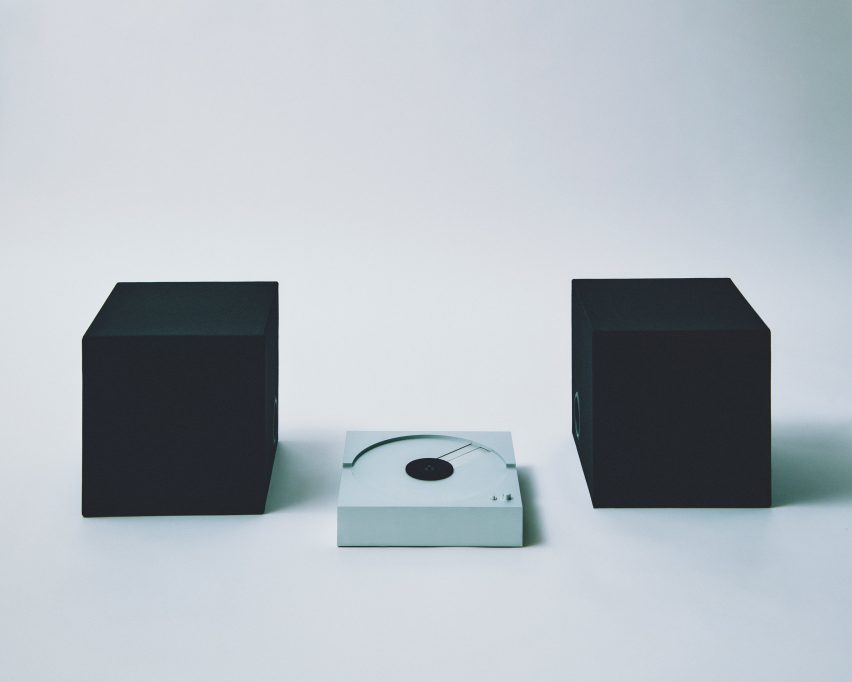 Metal record player surrounded by two square speakers