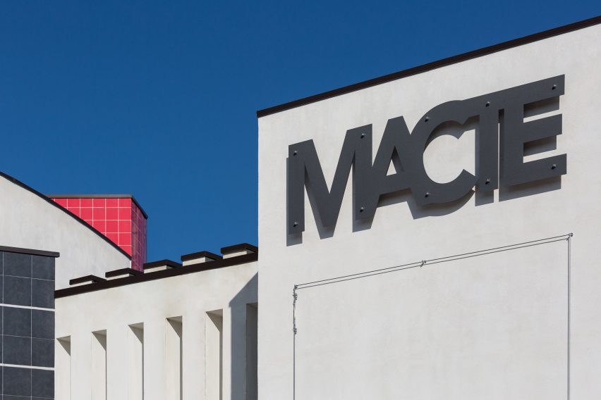 A cropped photograph of a white building against a blue sky.