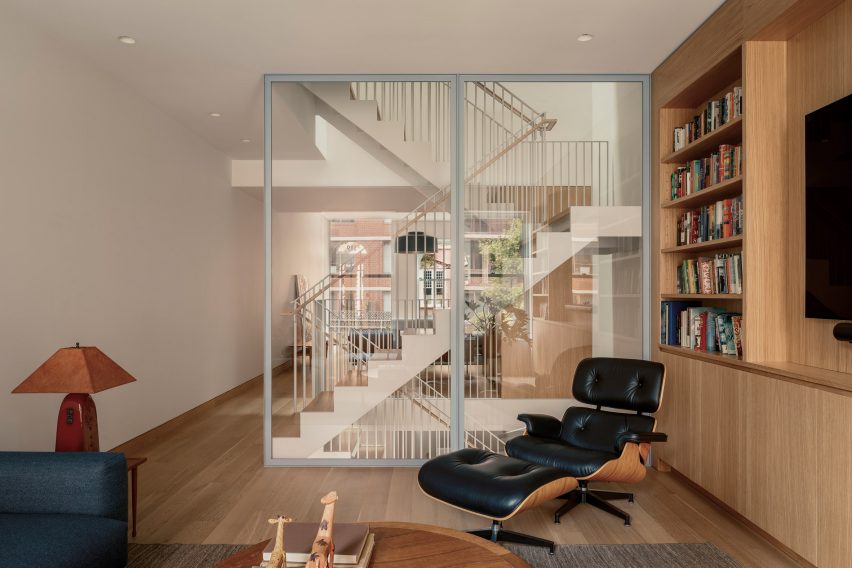 Library and TV room with an Eames lounge chair in front of a staircase