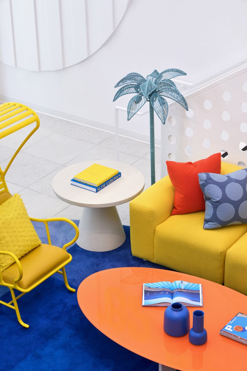 Yellow sofa and chair, with an orange coffee table, on a blue rug