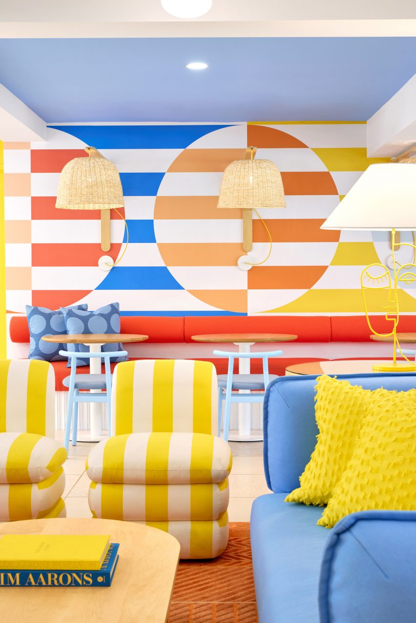Striped seating in front of a banquette below more stripes on the wall