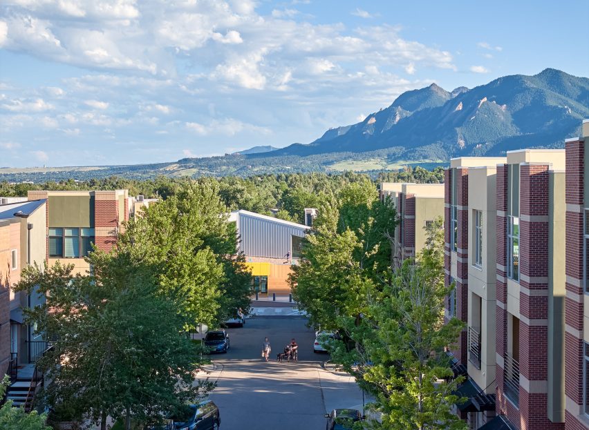 Boulder library seen through the trees with mountains in the back