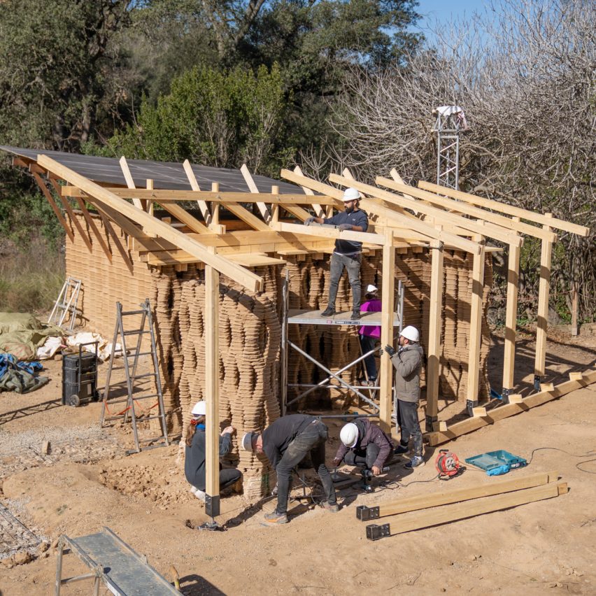 a photograph of a biege wooden structure being built in an outdoor space