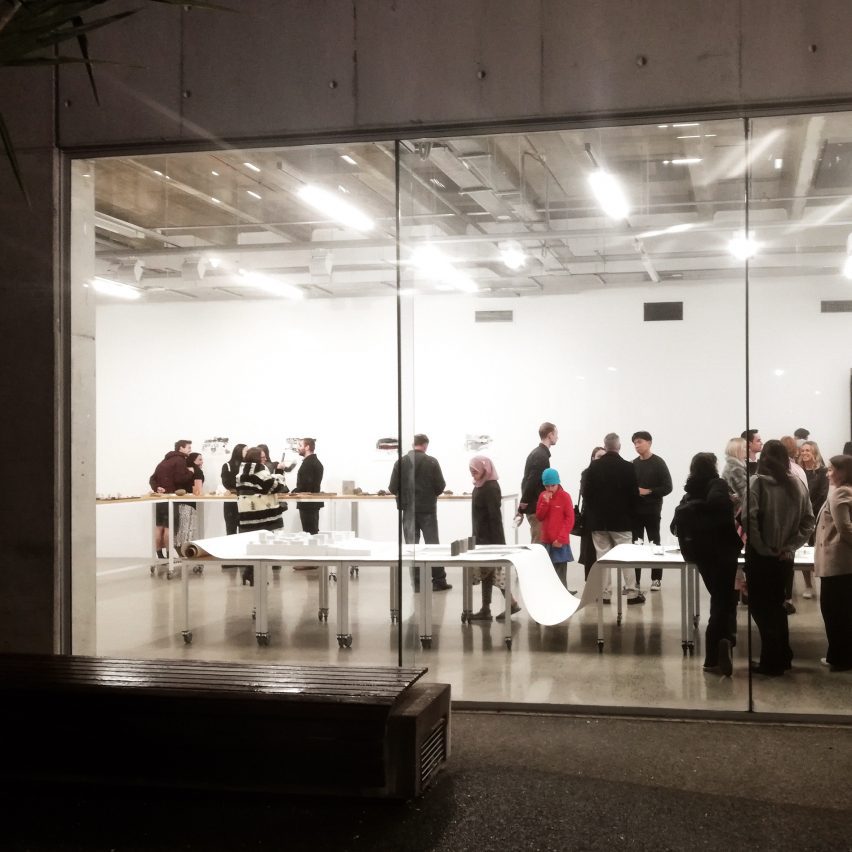 a photograph of a group of people standing in a room with large glass windows