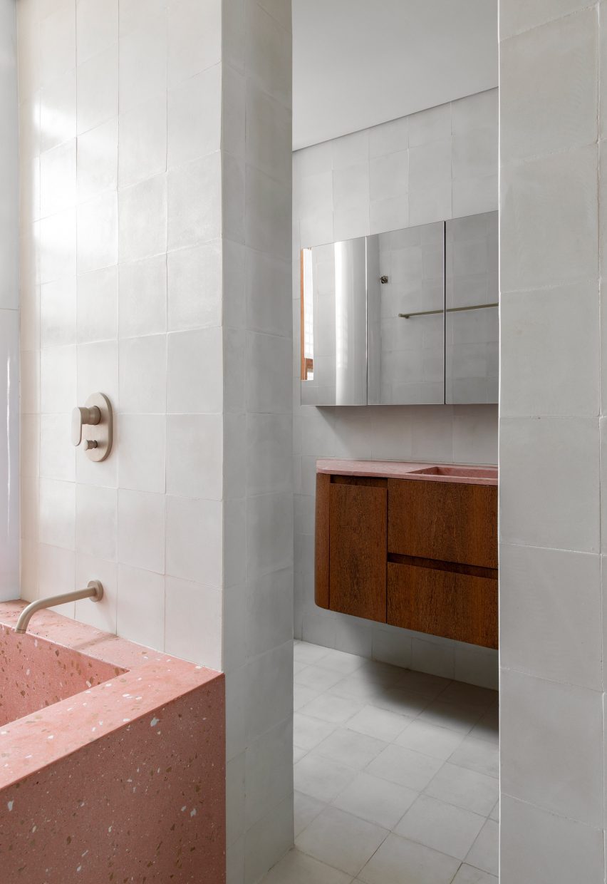 Pembe prekast beton küvet ve makyaj tezgahı bulunan banyo