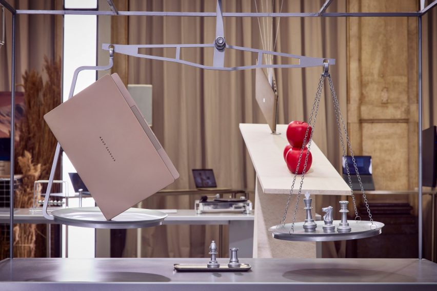 An ASUS Zenbook laptop on a weighing scale with chess pieces